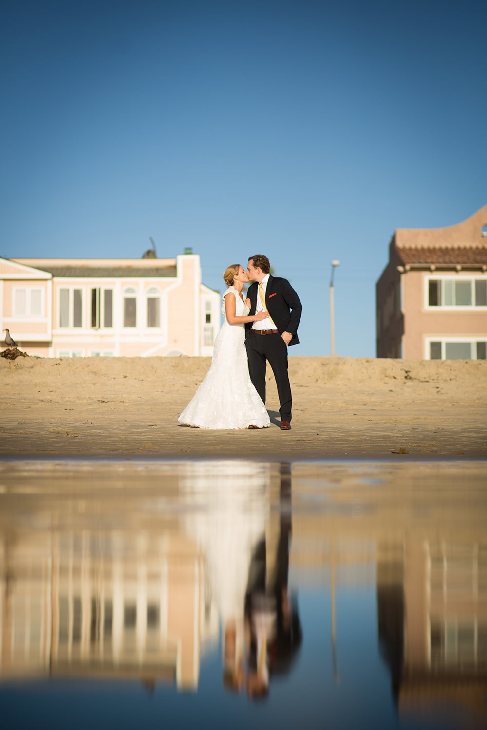 bride and groom by the bay reflecting off the water