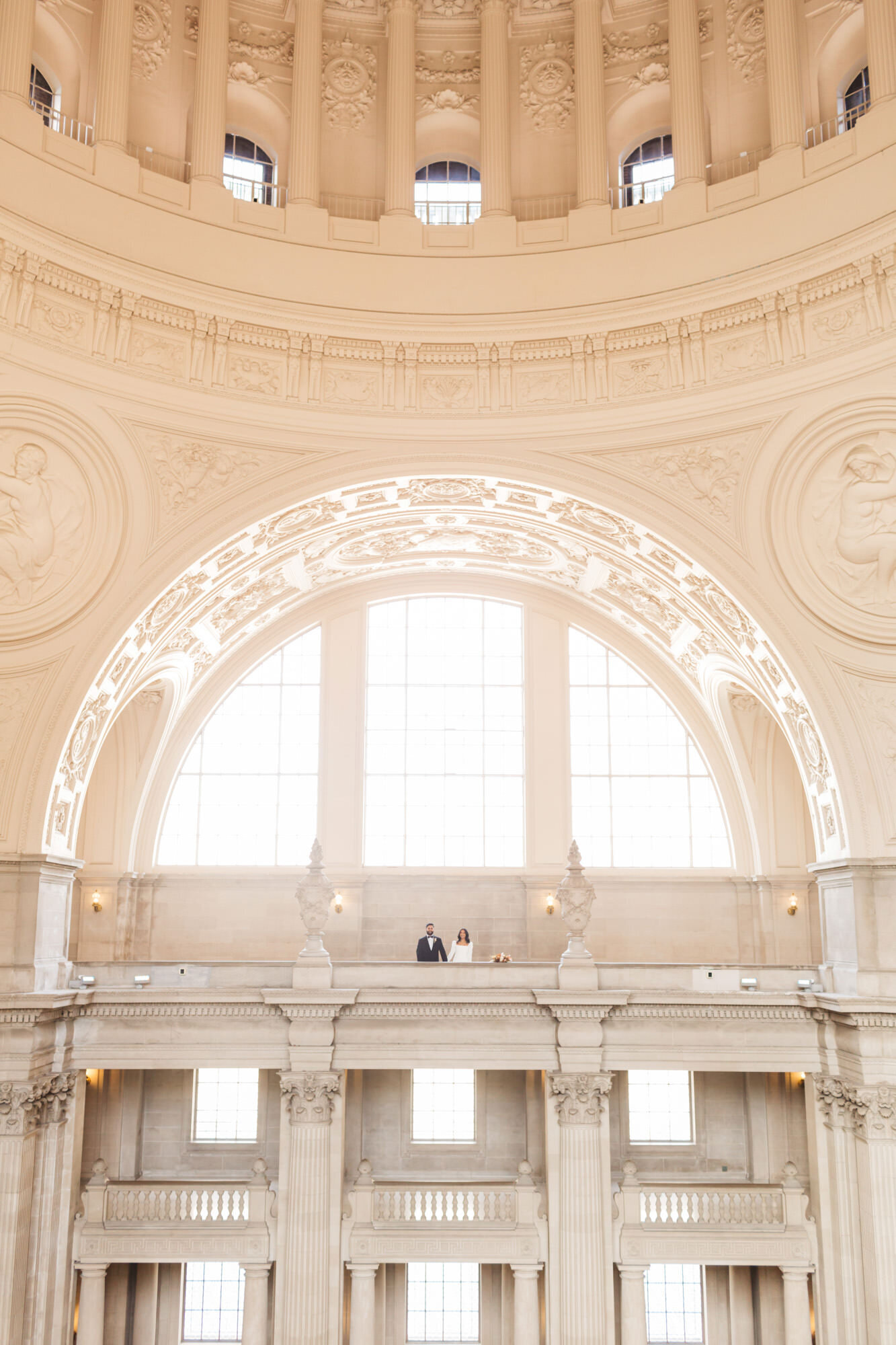 wide shot of couple standing on 4th floor at San Francisco City Hall