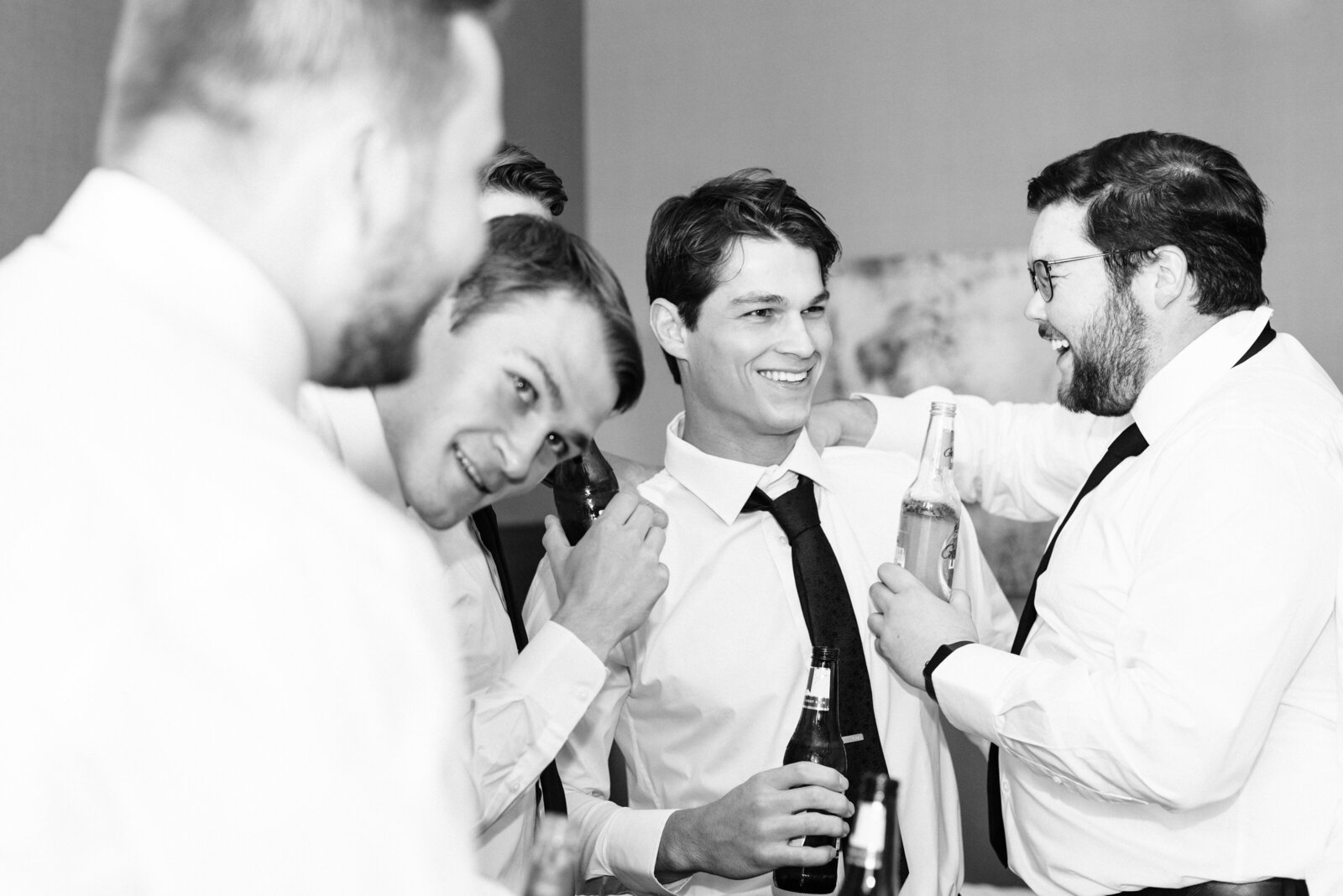 Groomsmen sharing beers and laughing