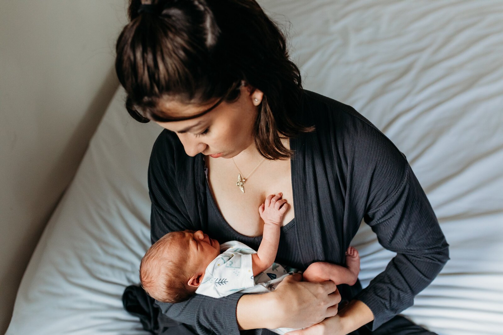 Mama holding newborn son during in-home  photography session.