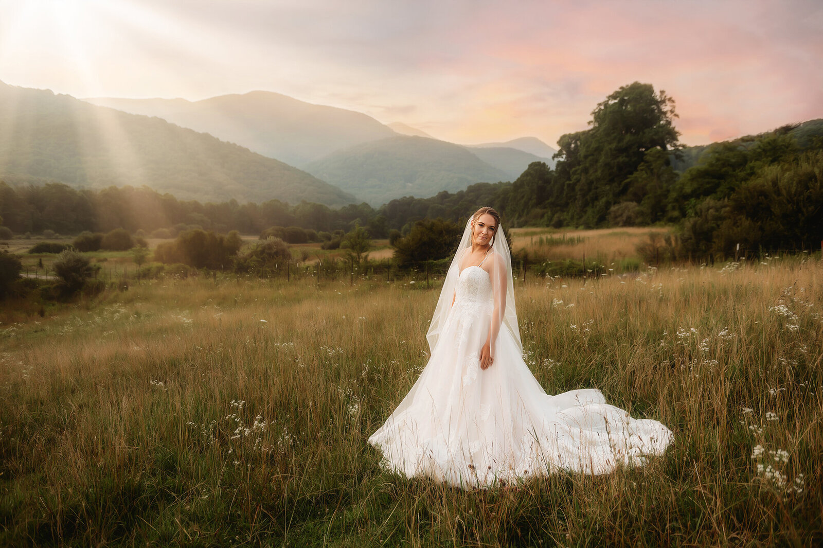 Bride poses for Bridal Portraits in a beautiful mountain field in Asheville, NC.