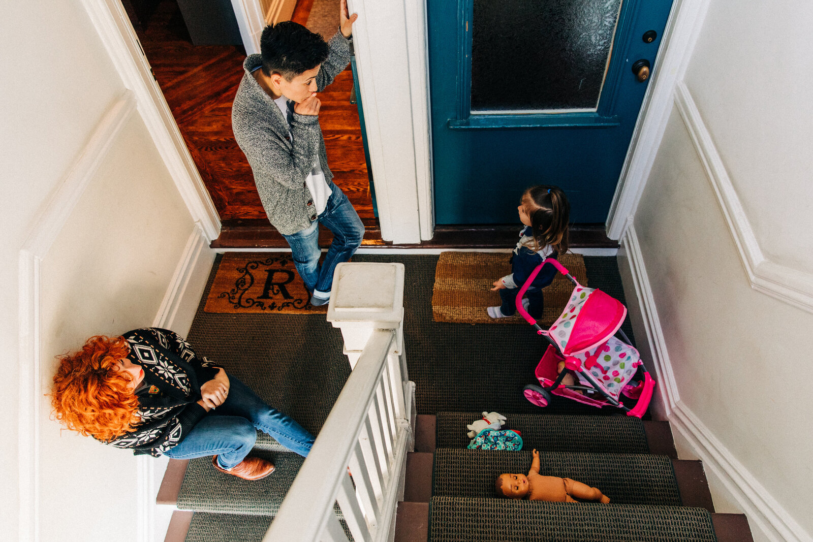 overhead photo of a family of three sitting in the stairwell of their san francisco walkup apartment