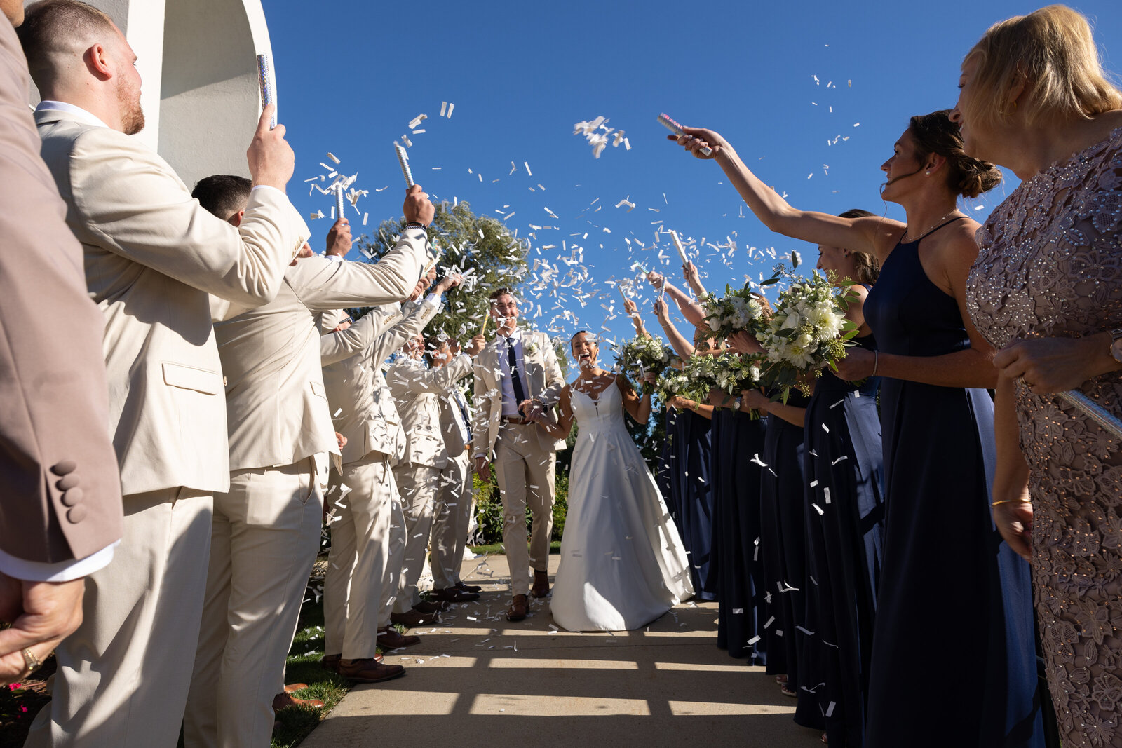 couple is showered with confetti while leaving church