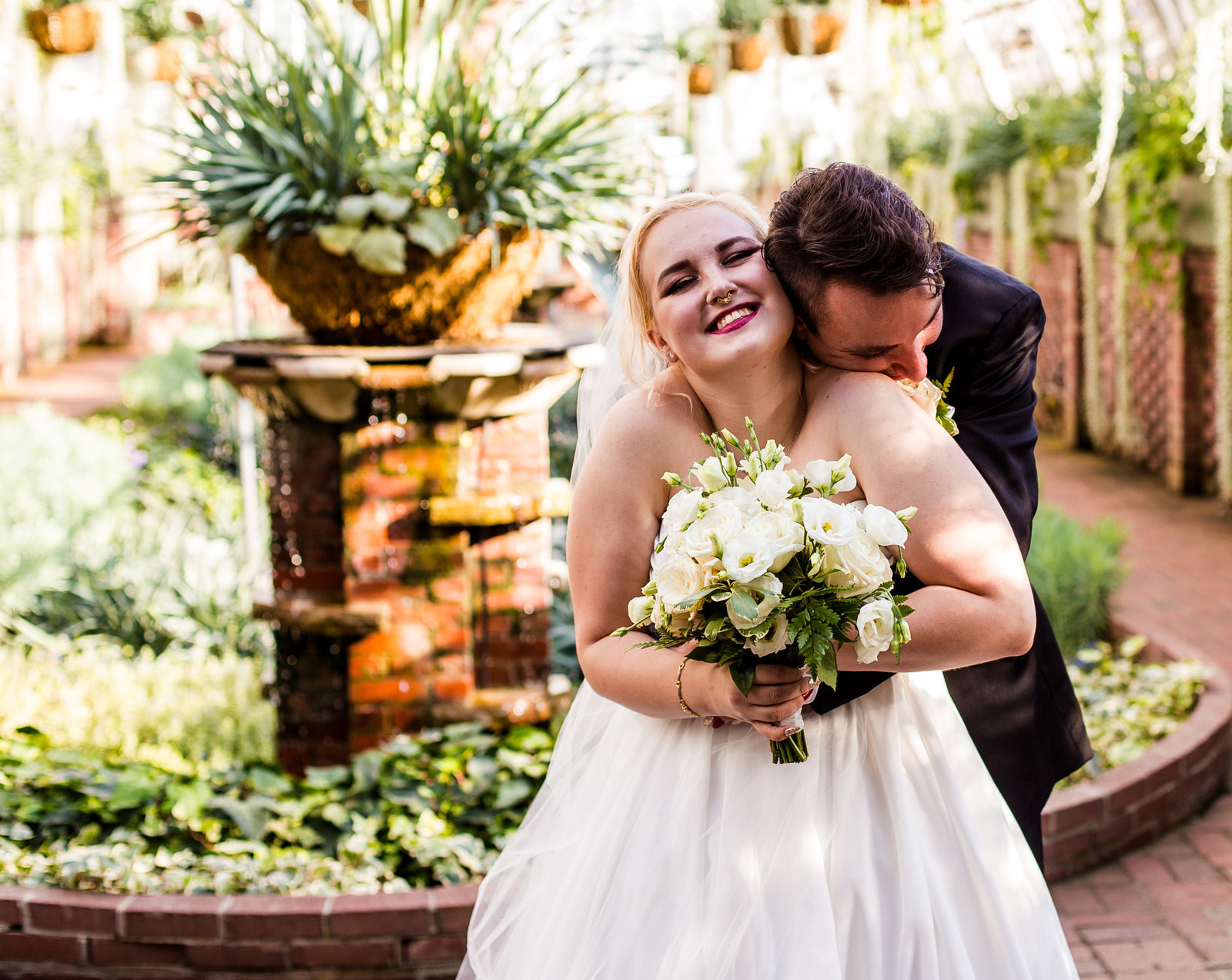 Groom embraces bride after their wedding in the Broderie Room of Phipps Conservatory