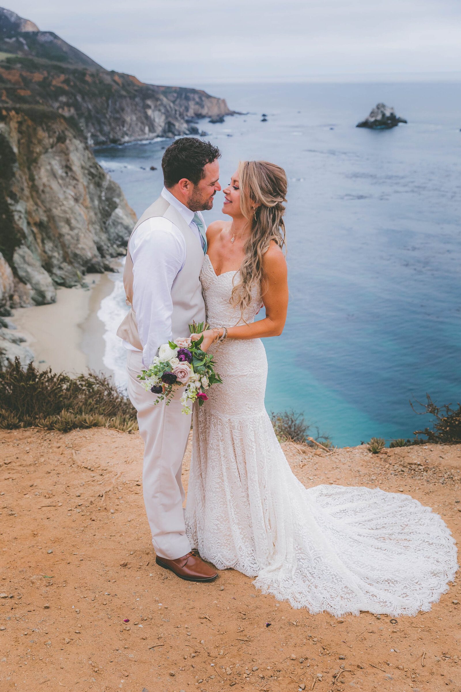 A groom and bride look into each other's eyes as they take wedding photographs at Bixby Bridge in Big Sur.