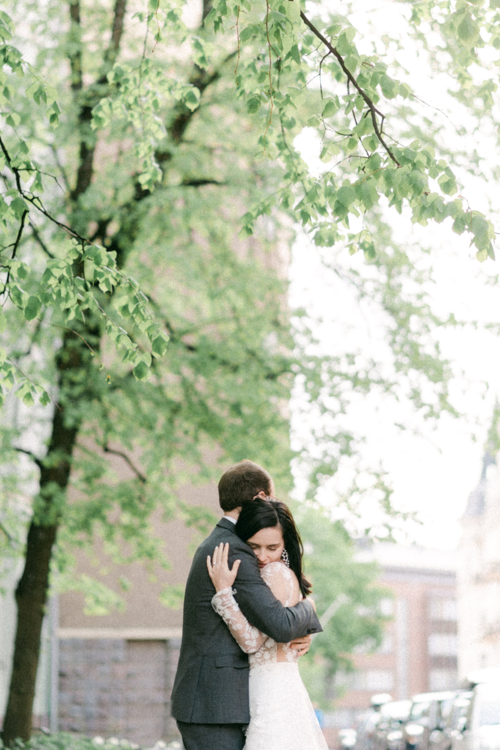 Emotional wedding photograph of a couple hugging on the street in Helsinki. Spring wedding image photographed by wedding photographer Hannika Gabrielsson in Finland.