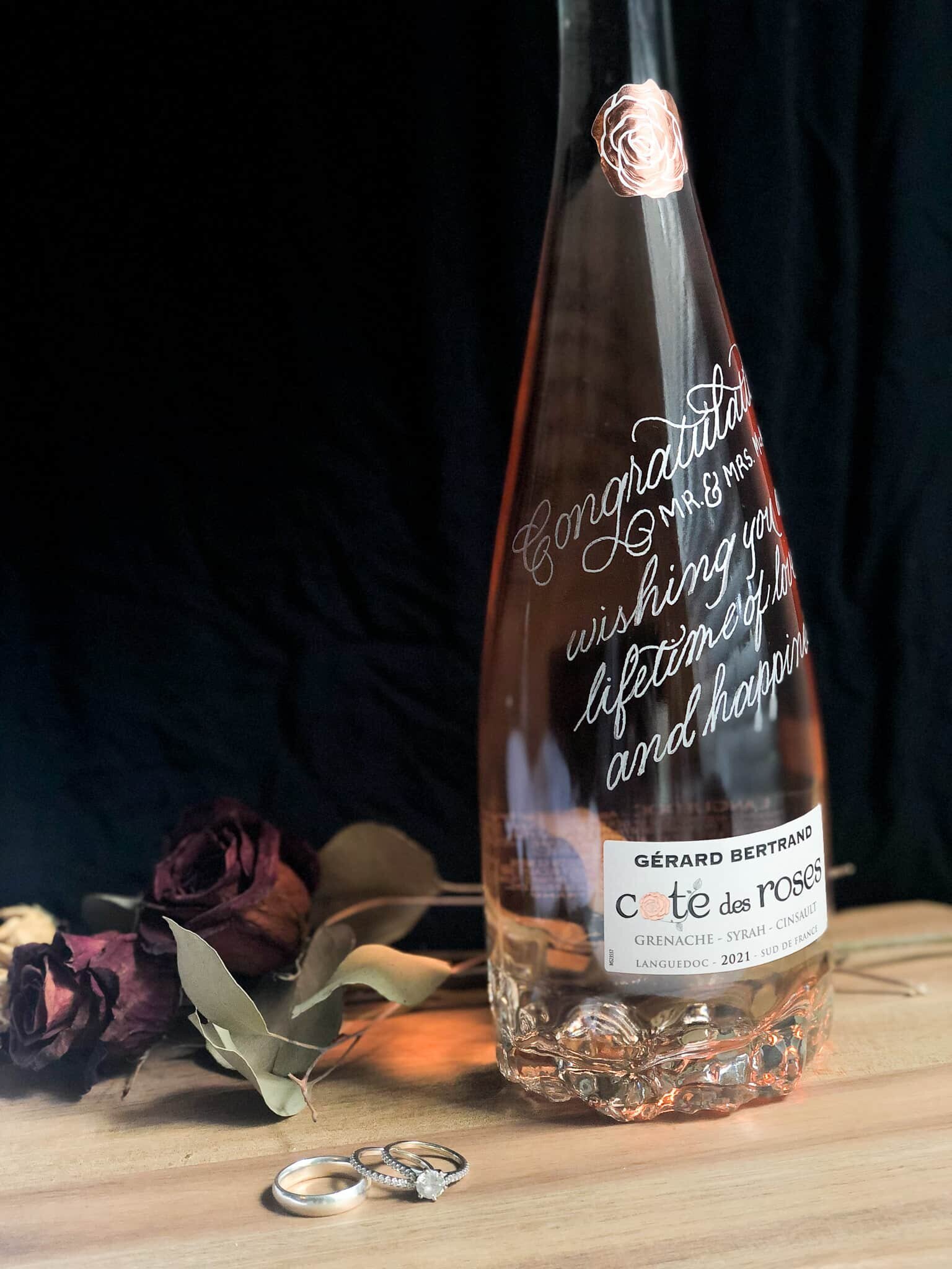 engraved bottle with dried flowers and set of rings