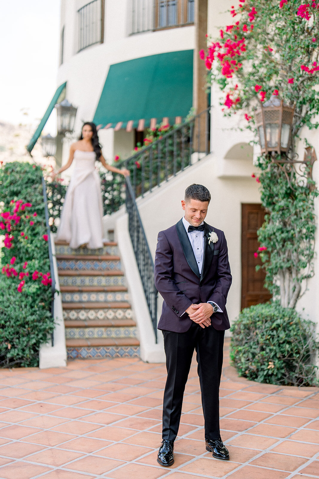 Groom sdurring the firstlook on terracotta steps under cascading bougainvillea for an editorial groom portrait in Simi Valley.
