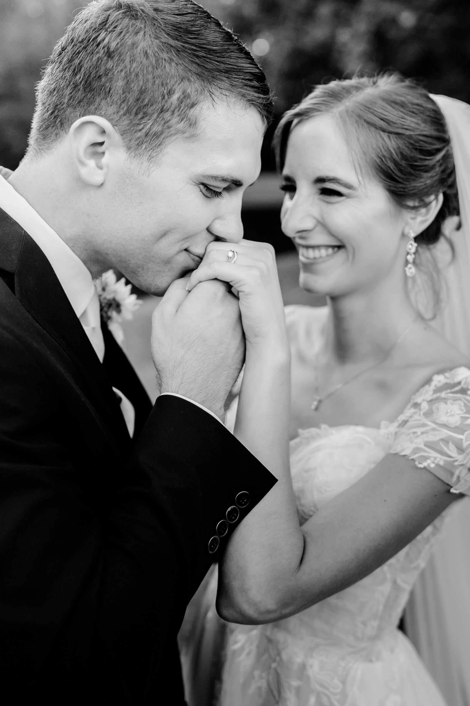 A groom kisses the hand of his bride during their Catholic wedding in Northern Virginia