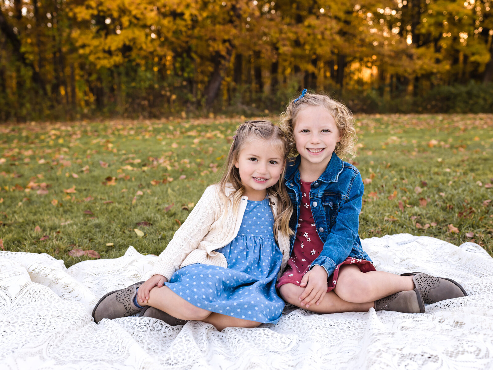 two sisters sitting on lace blanket for family portraits at brecksville reservation