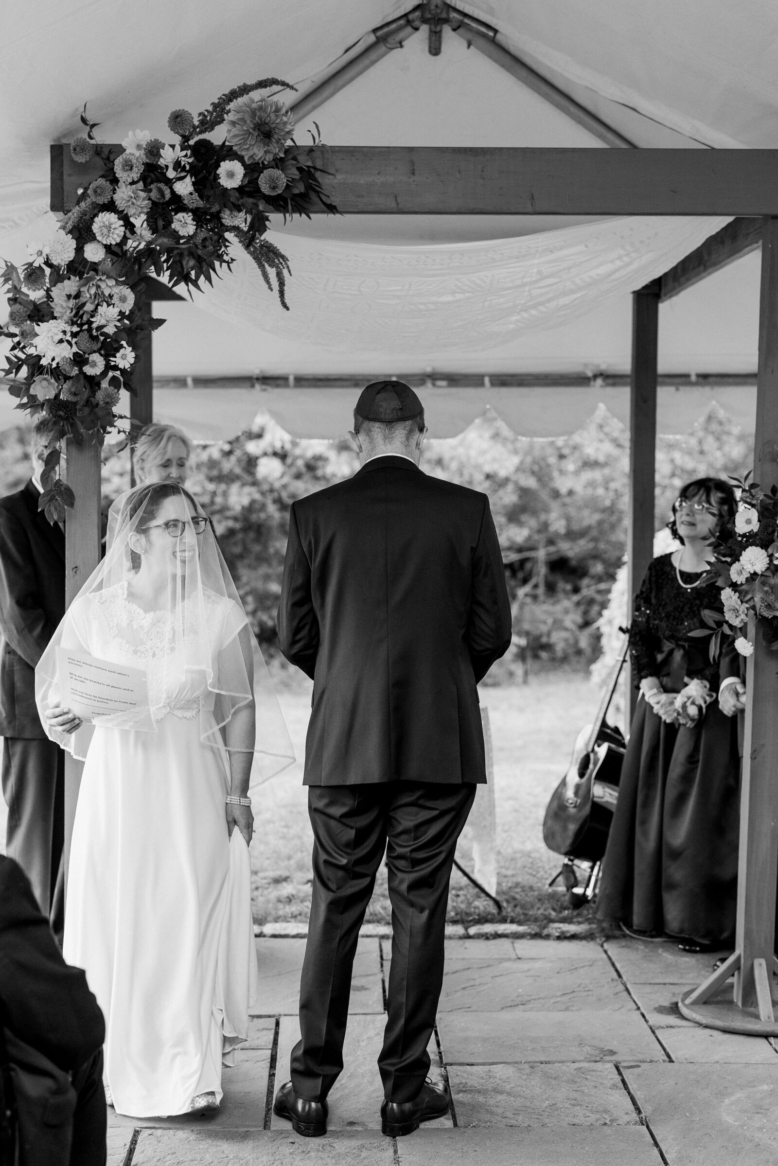 Black and white photo of a couple standing together at their wedding ceremony.