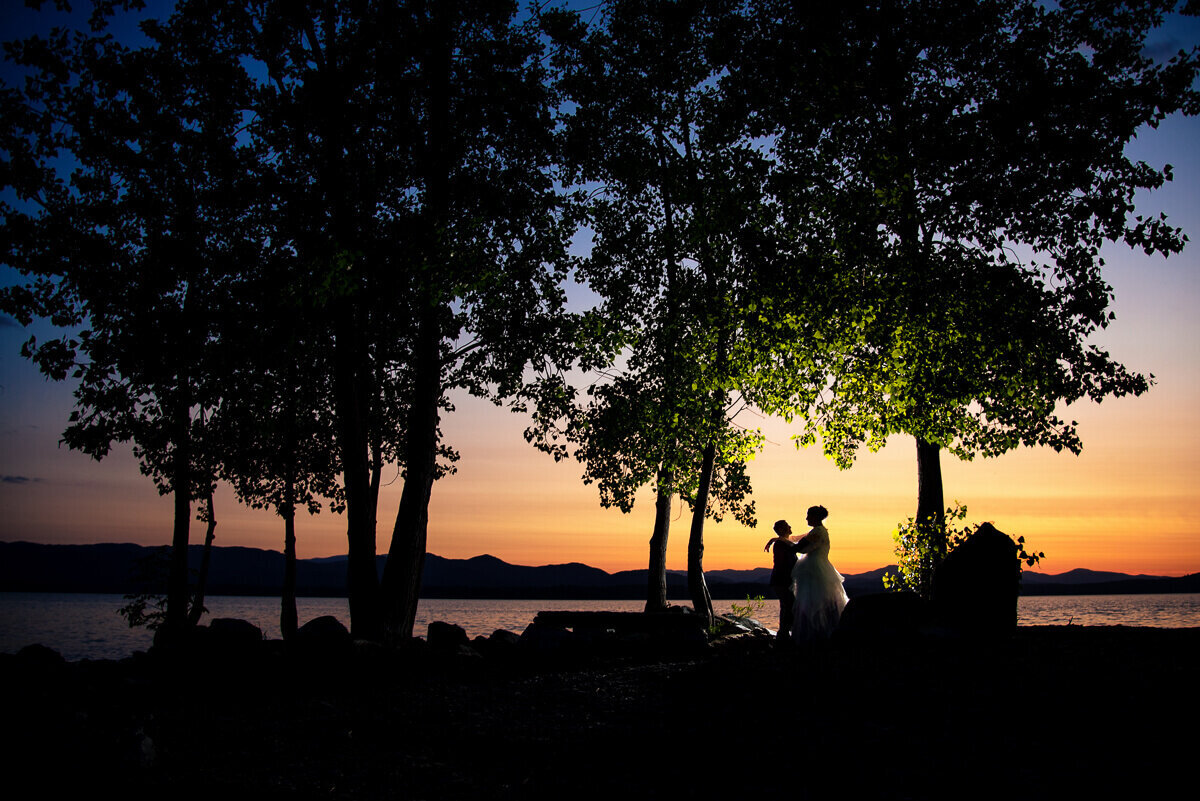 couple at sunset on banks of lake champlain