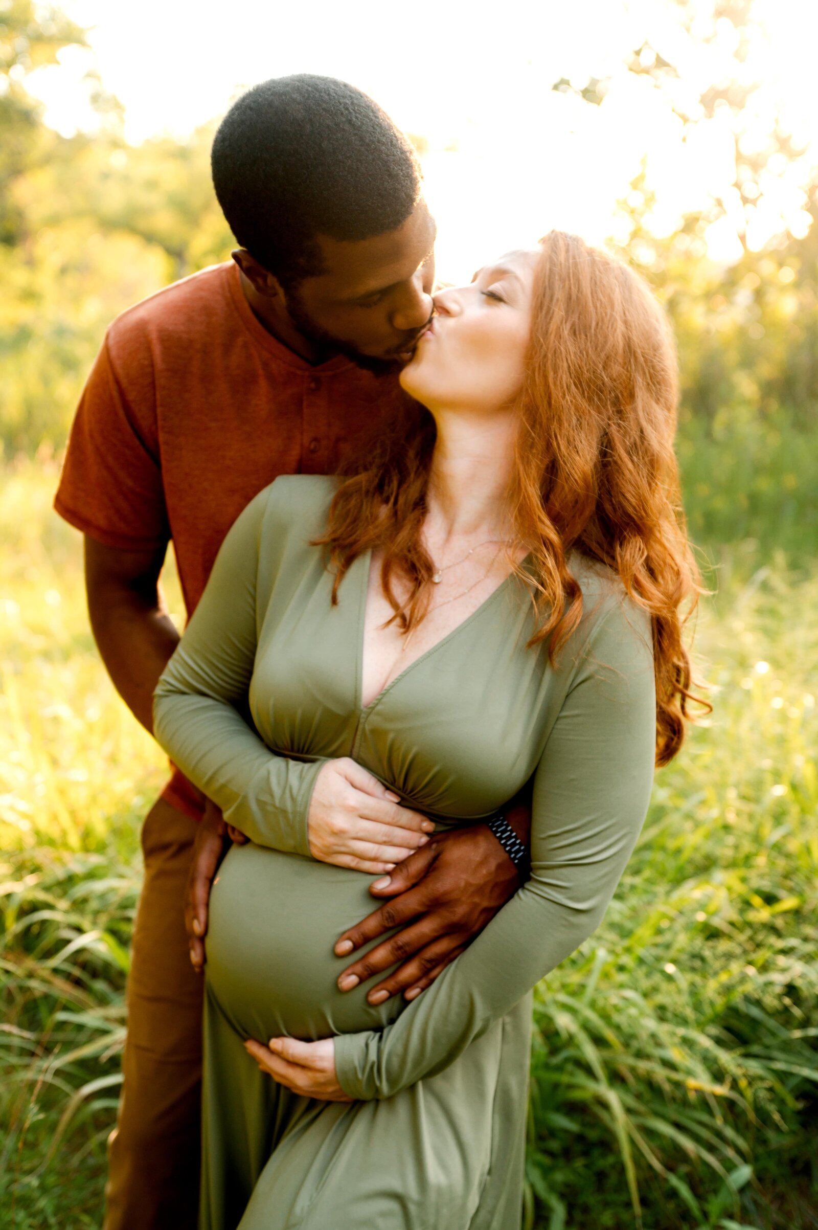 husband making wife laugh during a maternity photography session