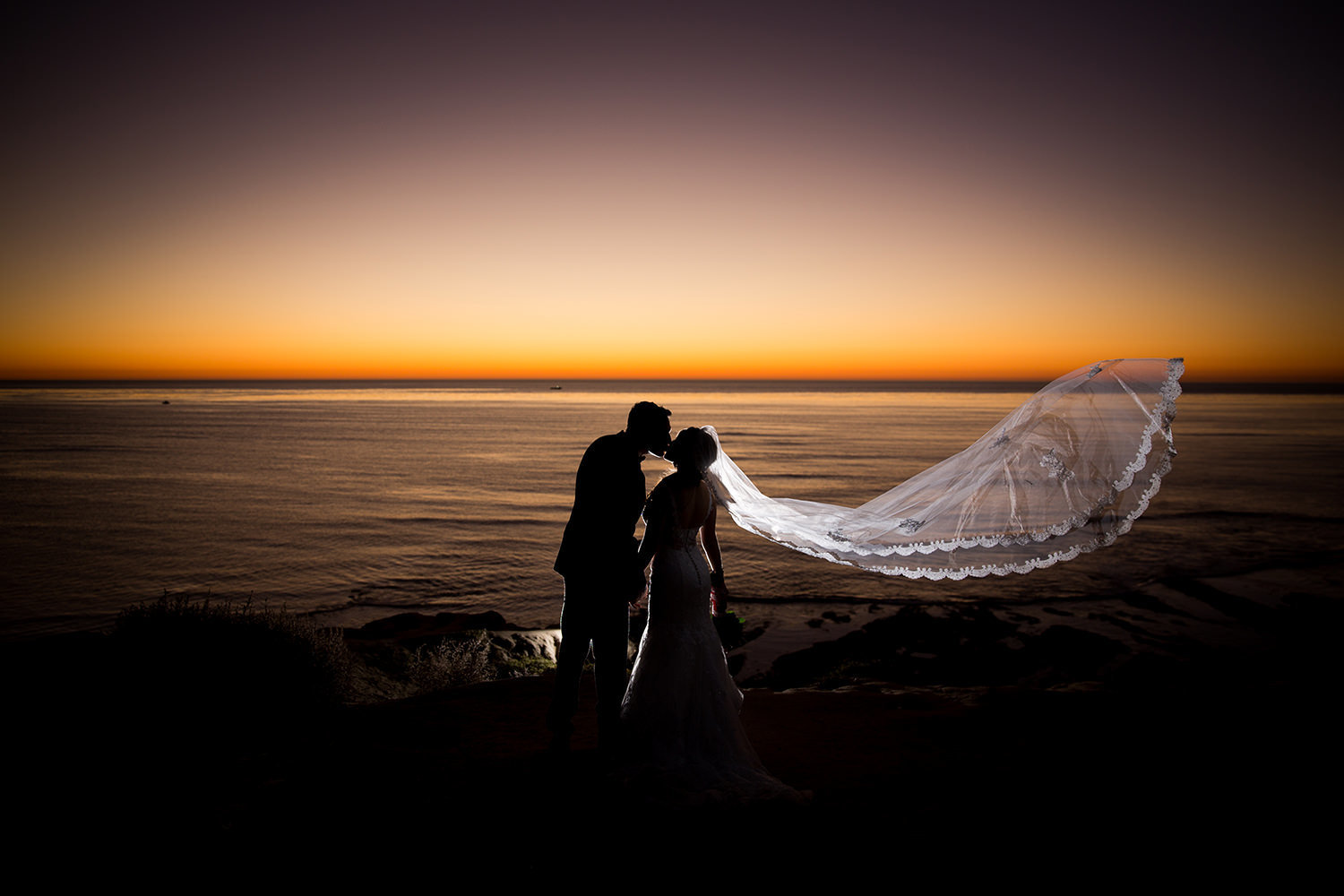 stunning sunset image with long veil on bride
