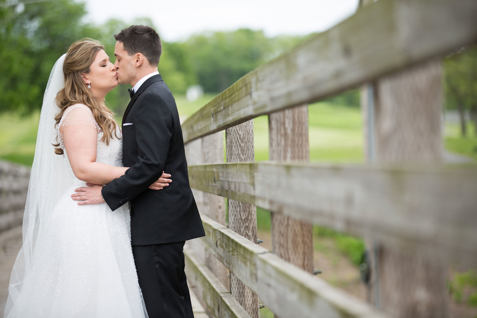 bride and groom kissing on the bridge at Engineers Country Club