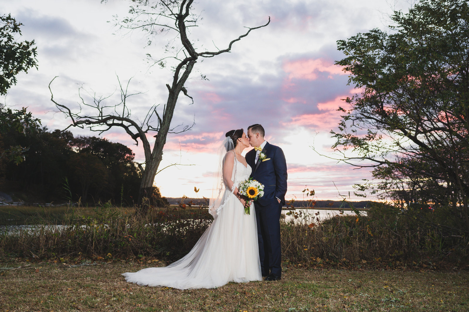 photo of bride and groom kissing near sunset from wedding at Three Village Inn
