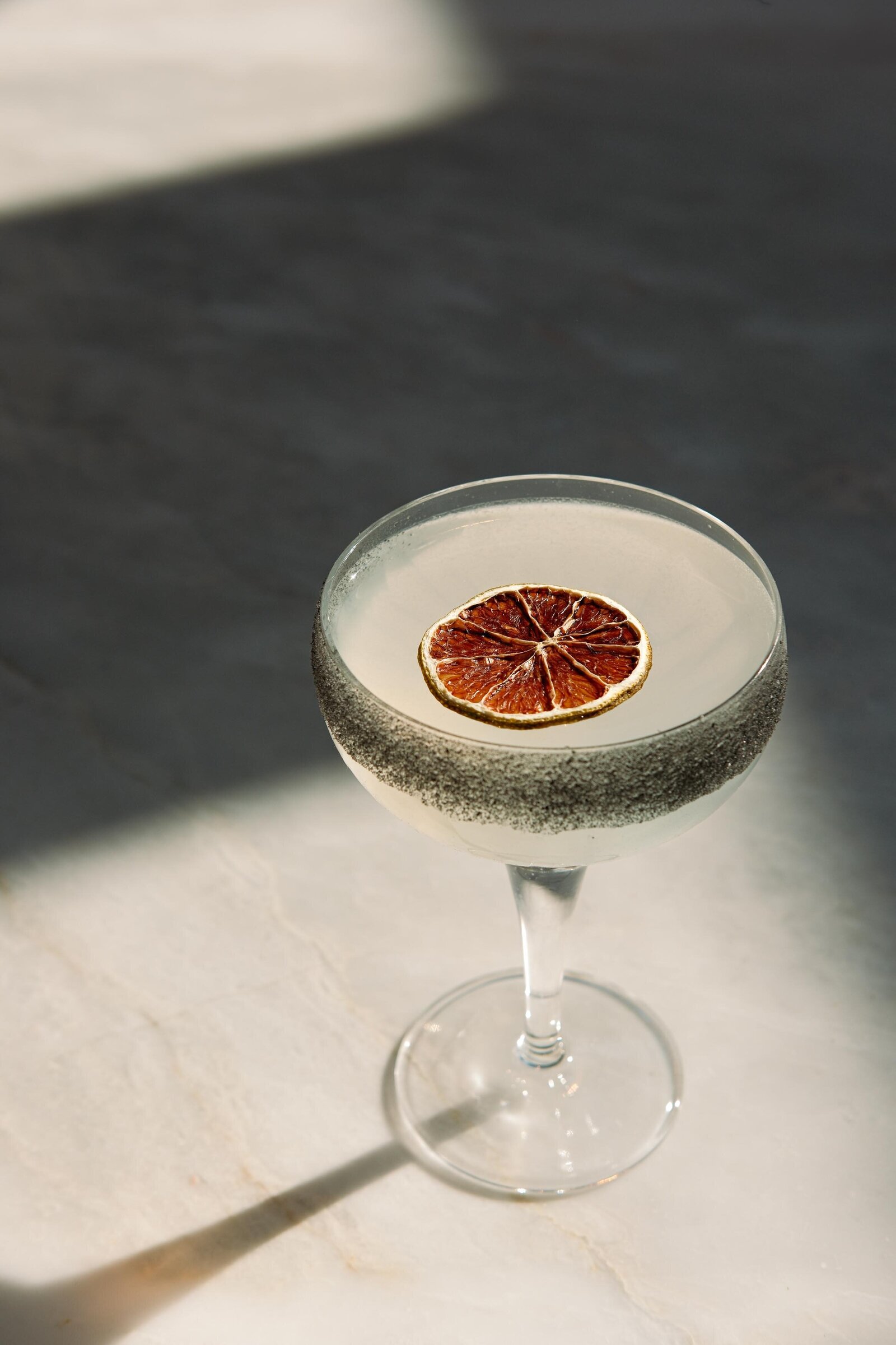 sfeervolle foto van signature cocktail met gedroogde limoen restaurant Amsterdam