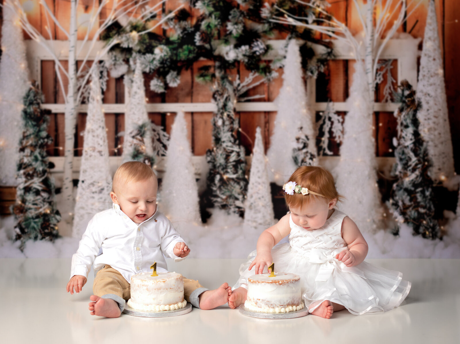 twin brother and sister smashing cake for first birthday photoshoot
