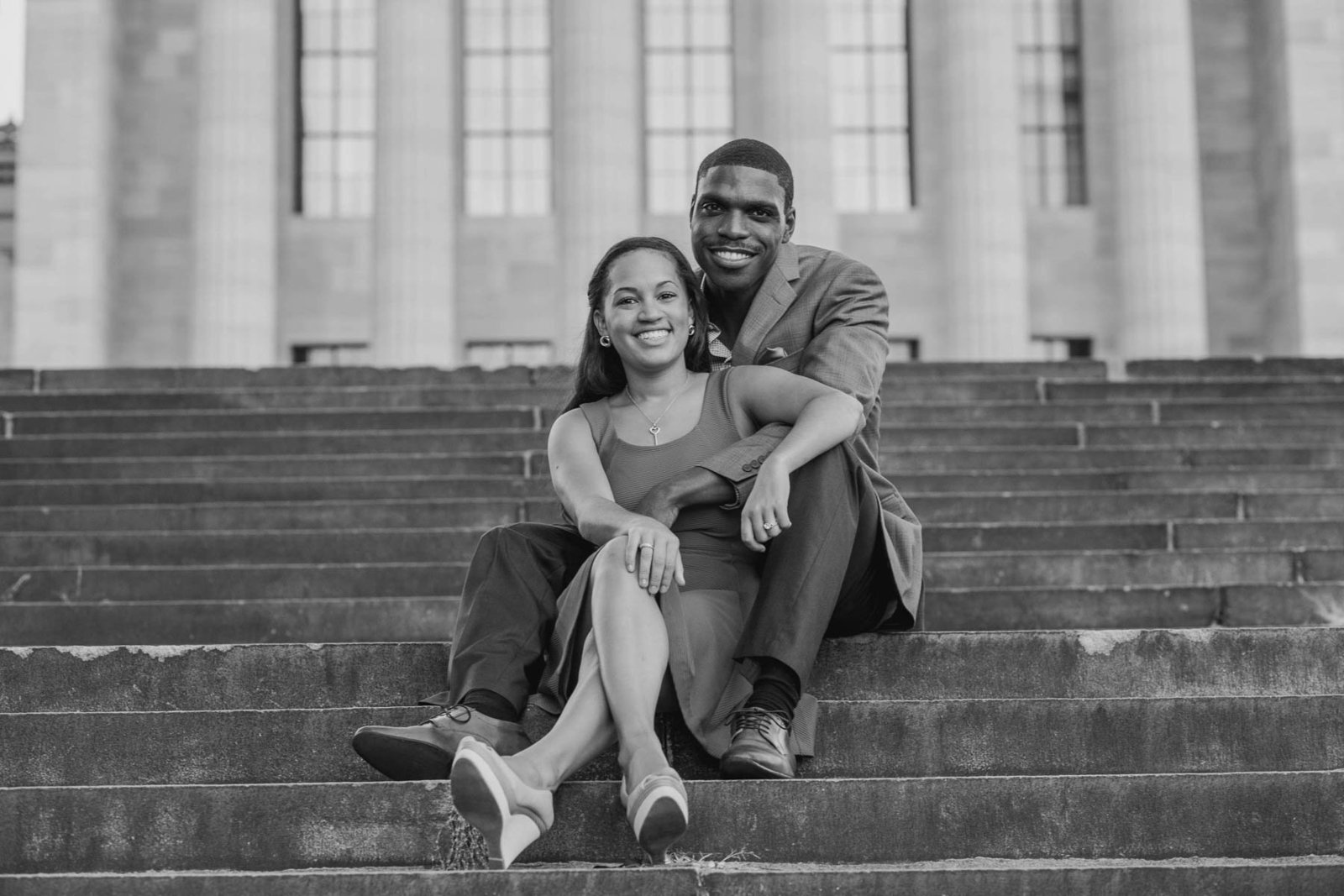Engaged couple sitting on the steps of the art museum, Philadelphia, Pennsylvania