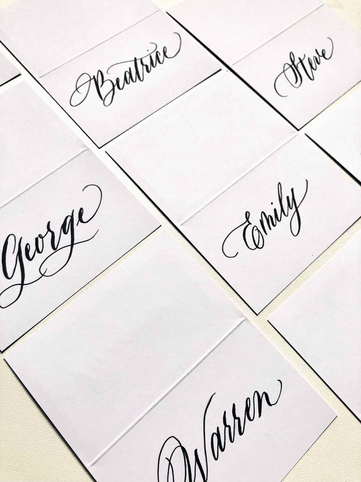 set of place cards with a modern calligraphy style