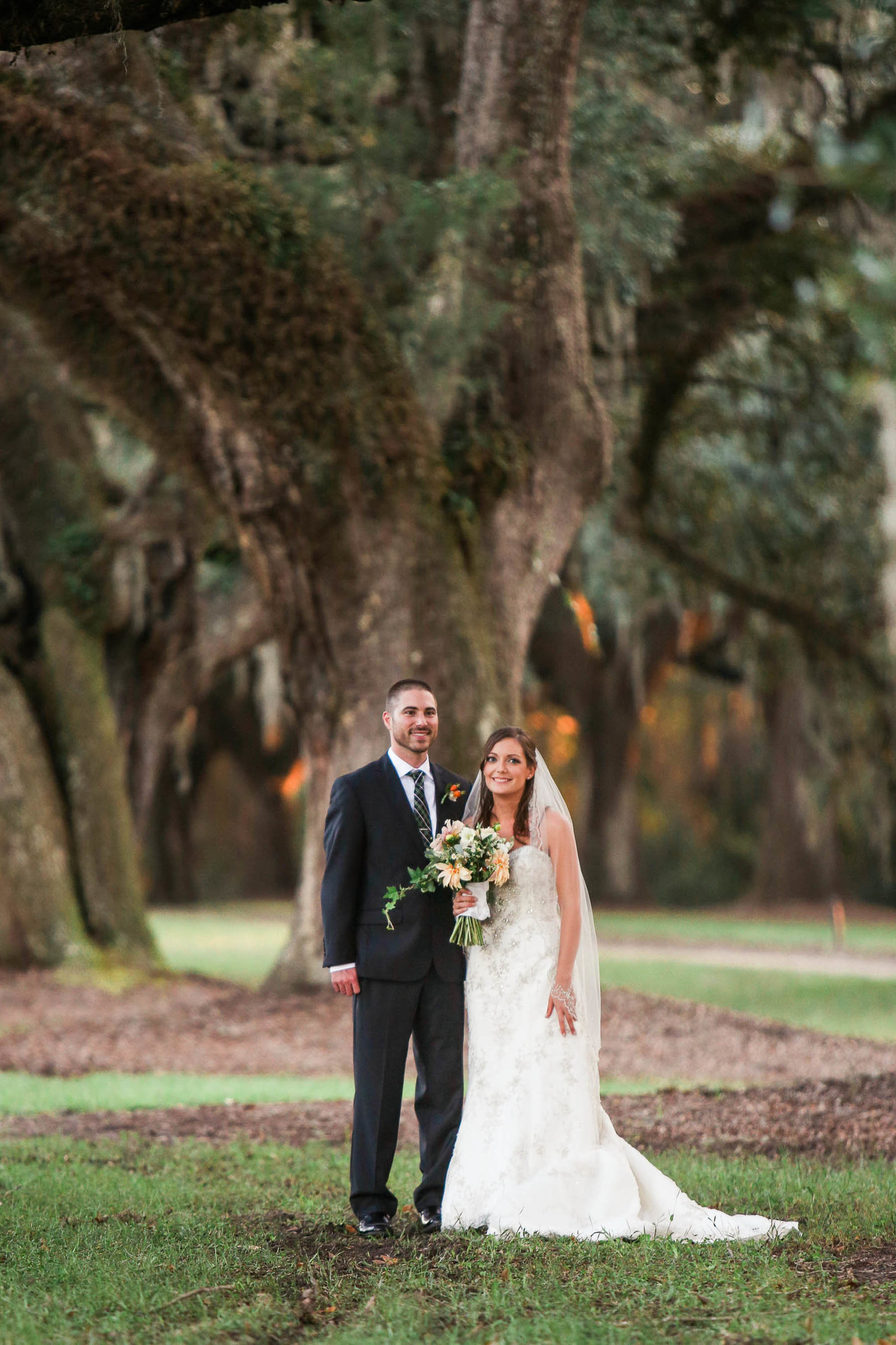 Bride and groom stand by oak tree, Boone Hall Plantation, Charleston, South Carolina