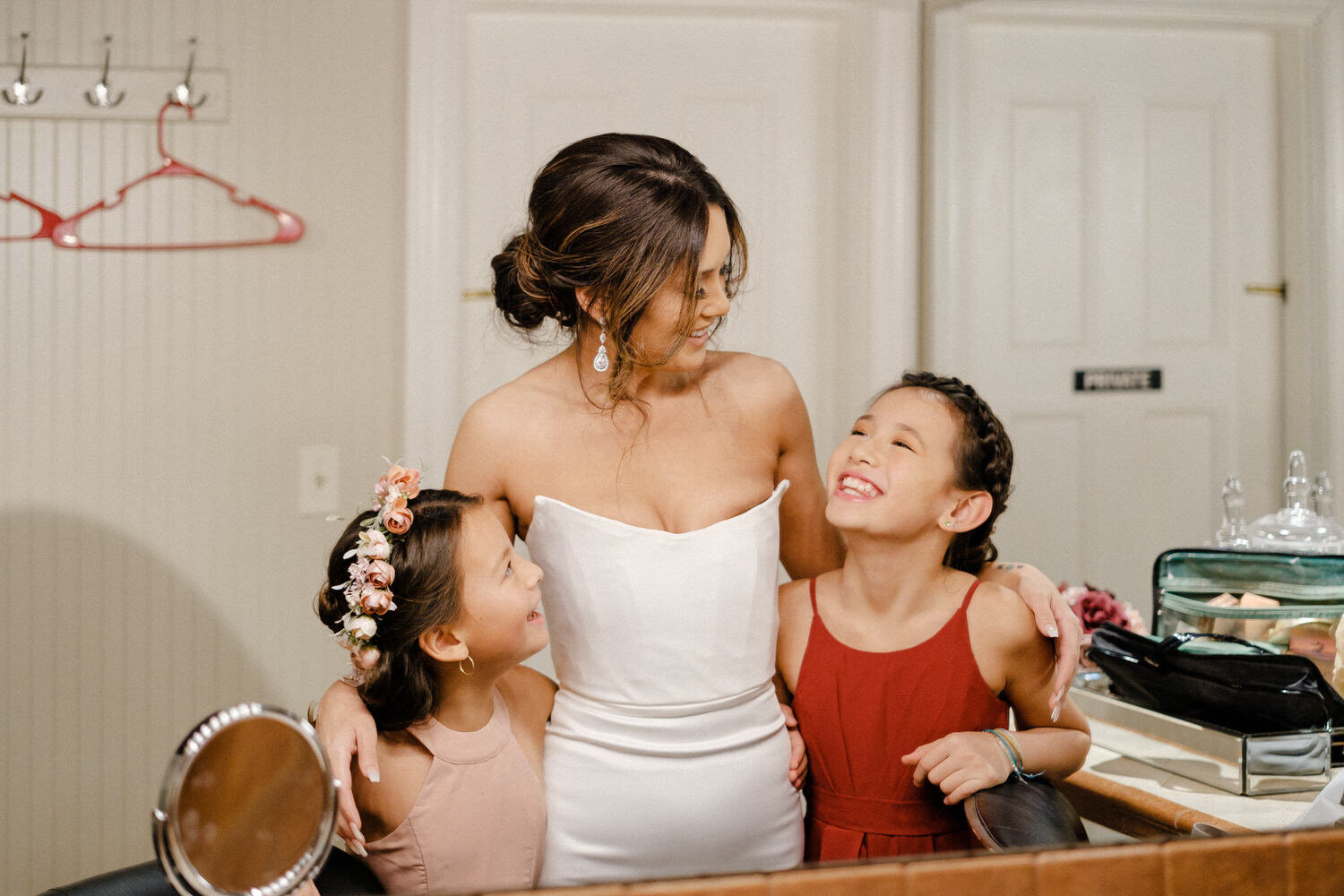 Bride hugs her new step-daughters as they get ready for the ceremony
