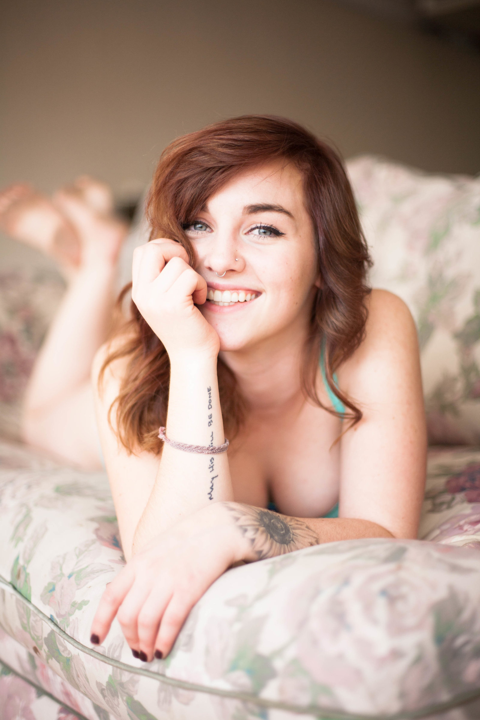 Woman wearing lingerie smiling during a boudoir photography session.