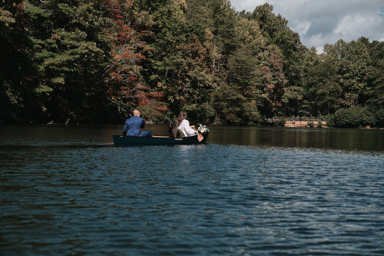 Eloping couple rowing a canoe on wedding day