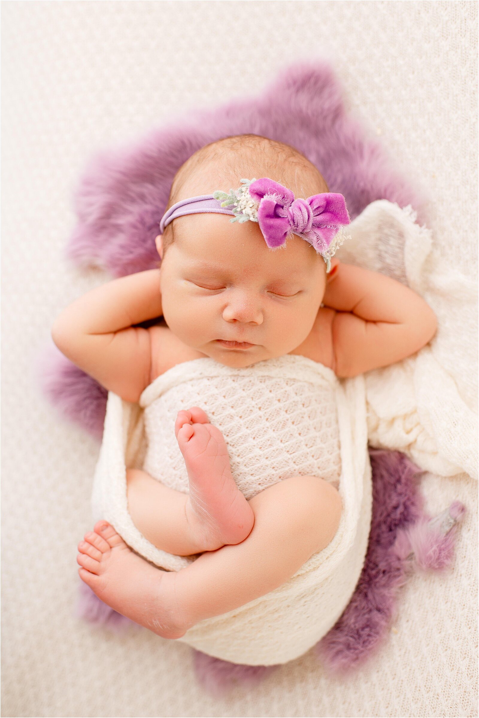 newborn baby in cream and purple