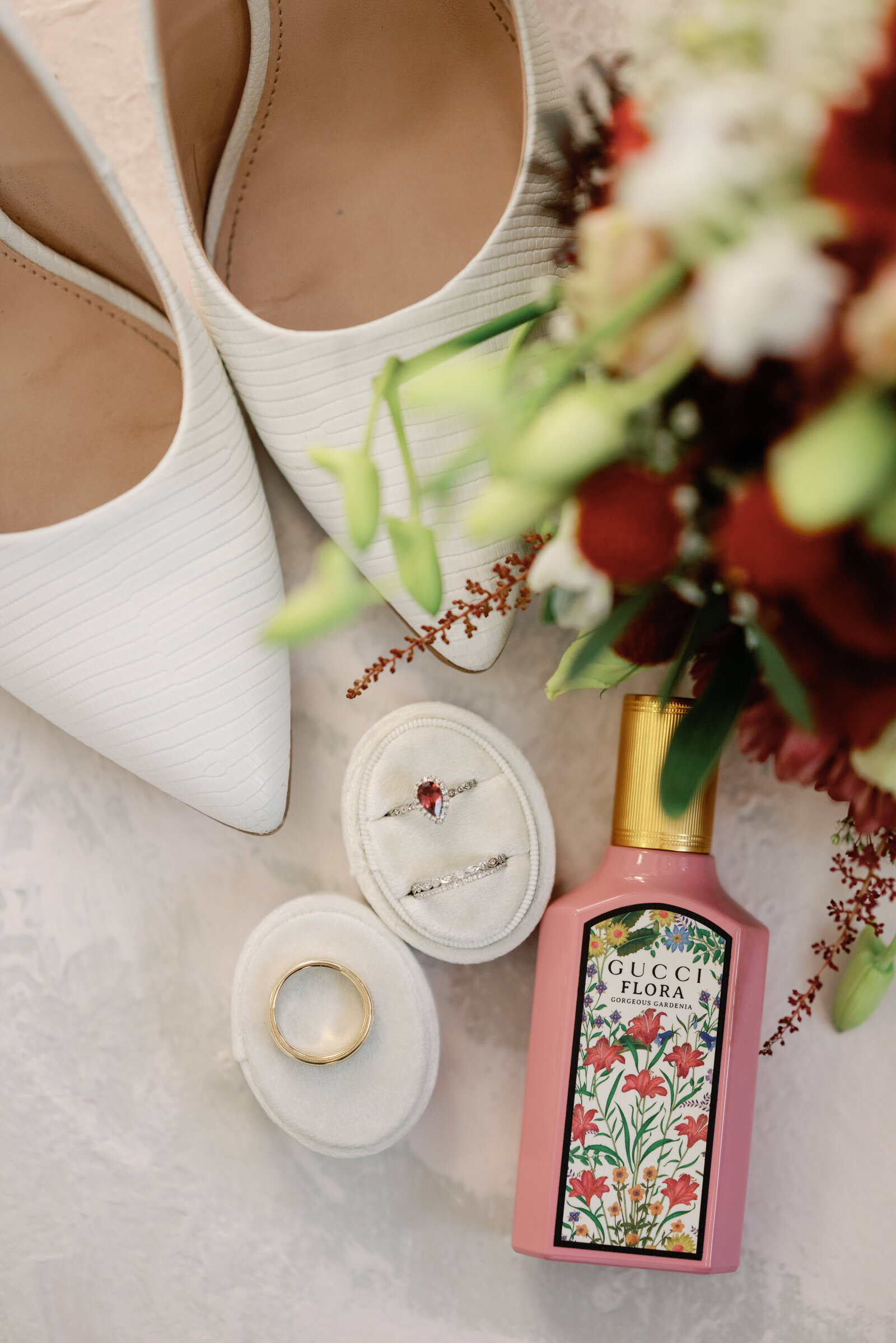 Closeup details of wedding rings, the brides perfume, brides shoes and brides bouquet