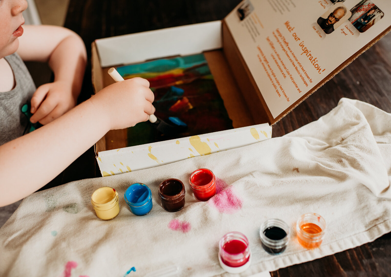 Branding Photographer, a child's hand dips a paintbrush in paint