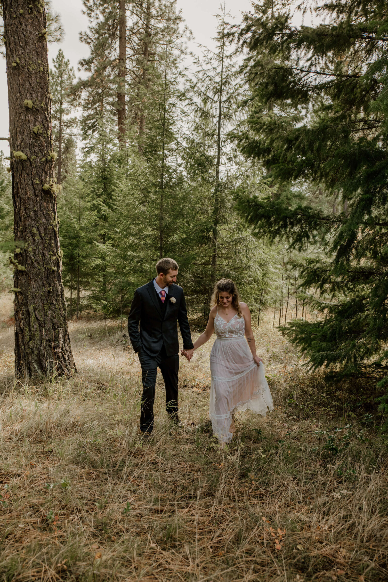 Bride and Groom walking in forest.