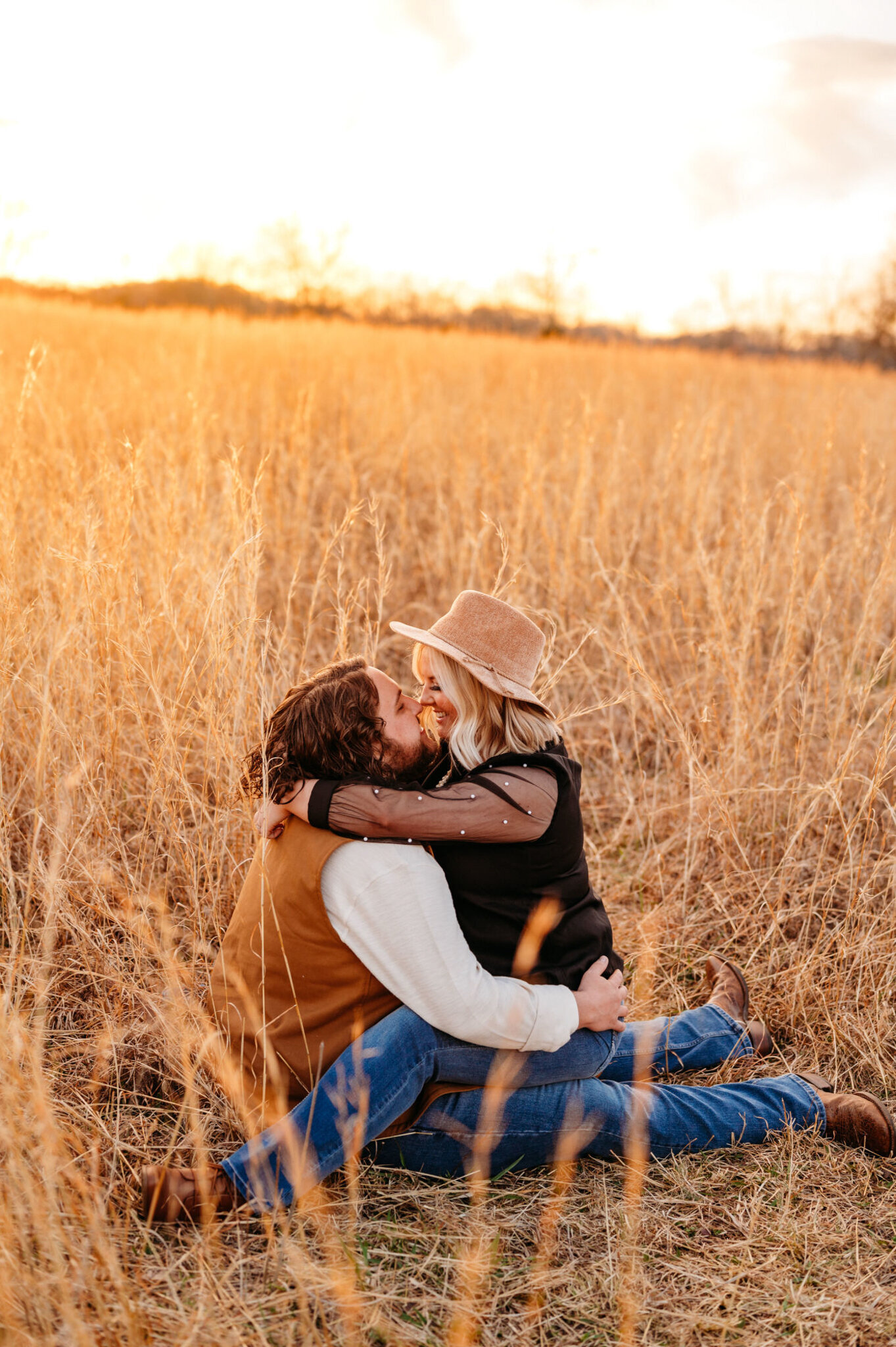photo of man and woman cuddling in a field