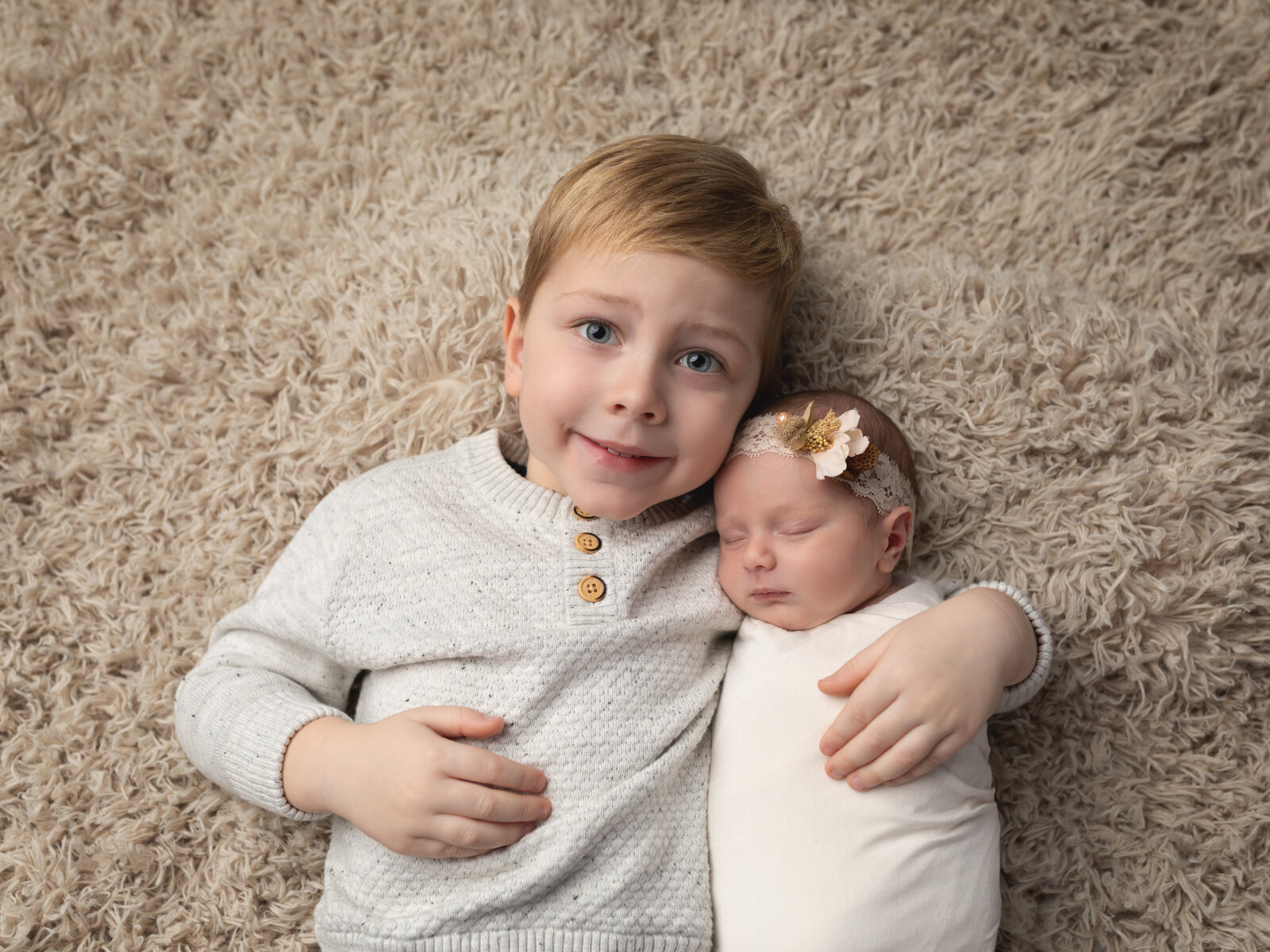 brother holding baby sister for photoshoot