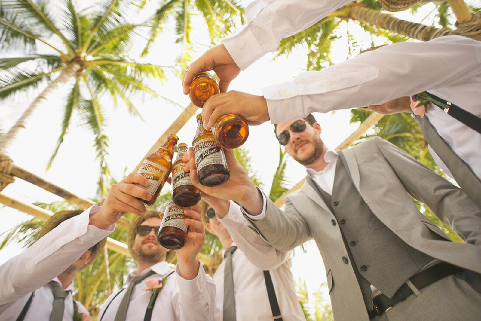 Groom's men holding a bottle of beer tossing