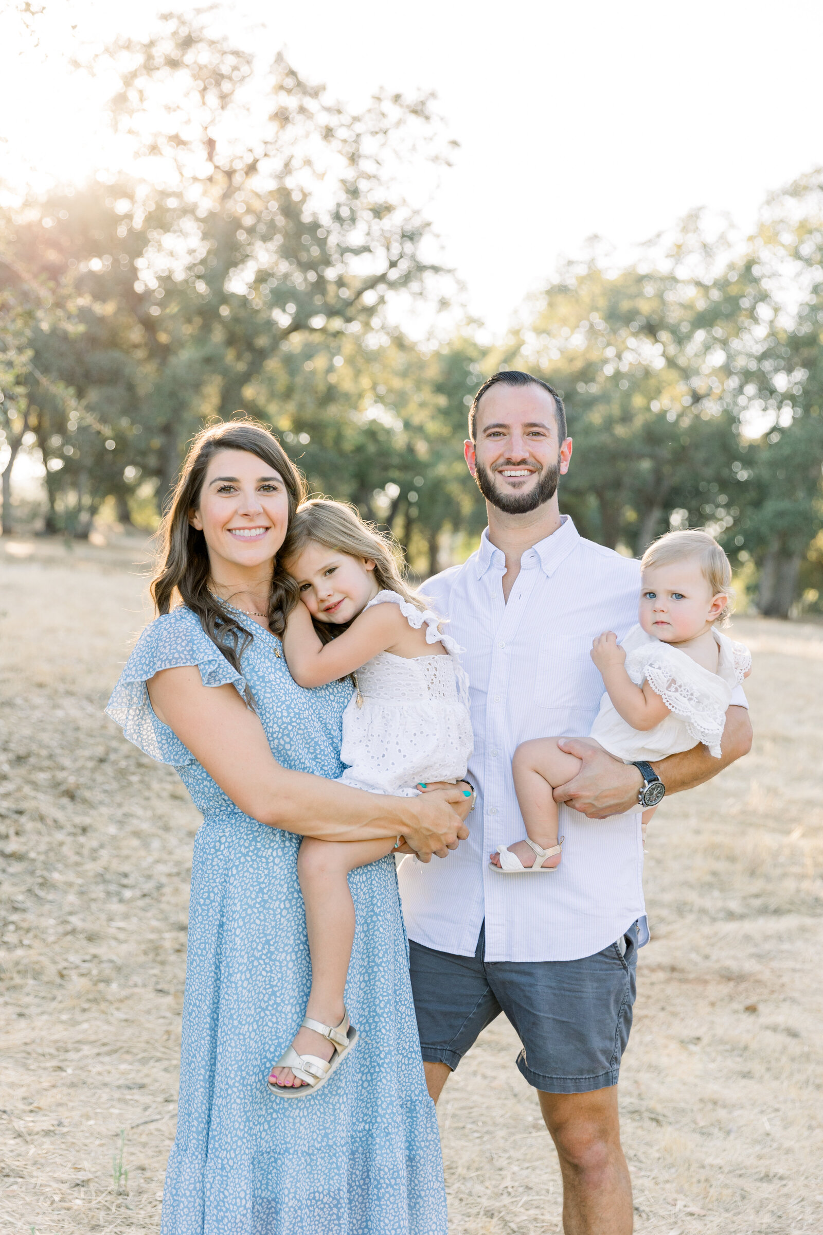 Young family with two girls smiling together taken by Sacramento Newborn Photographer kelsey Krall