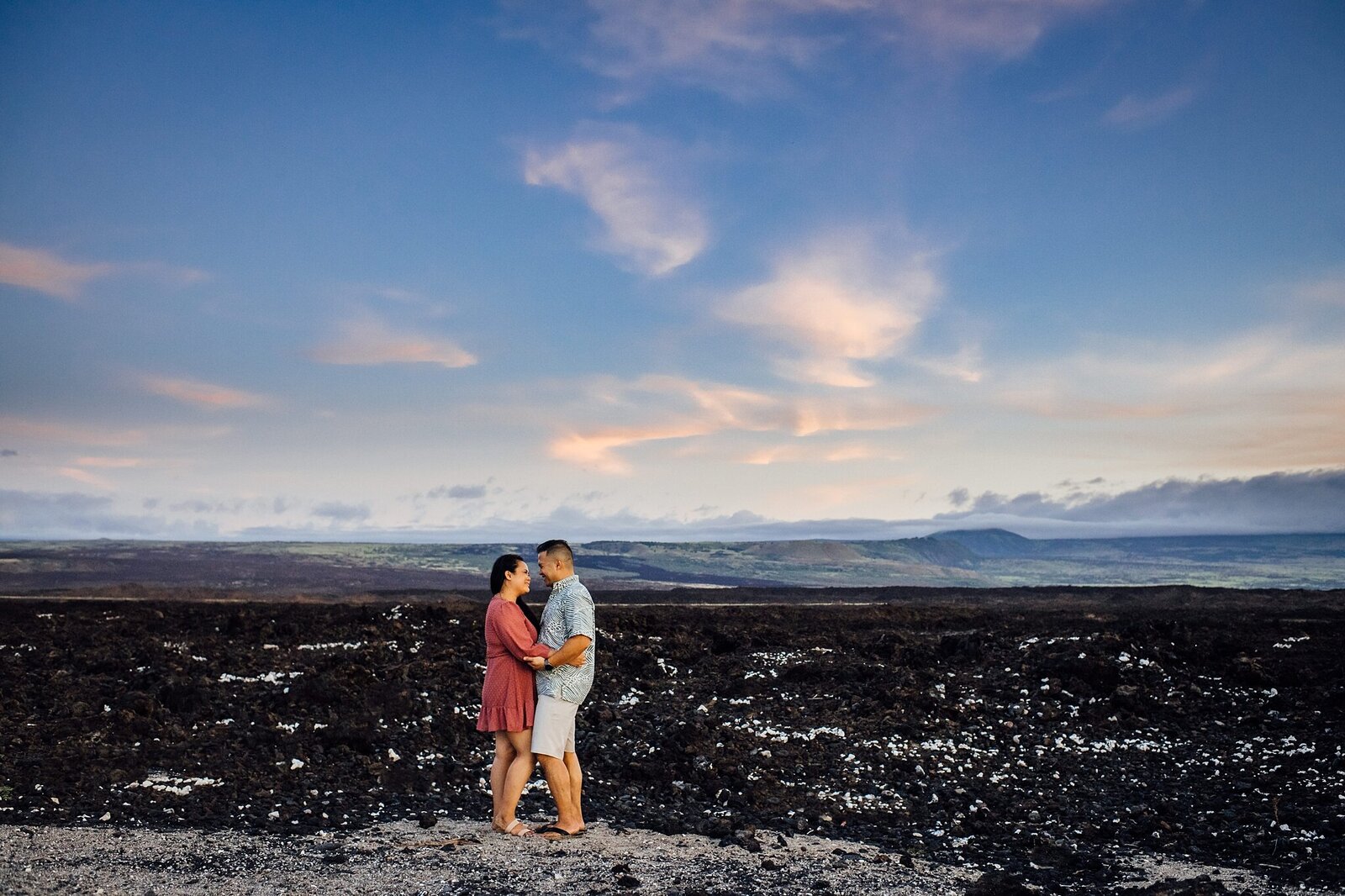 engaged couple against the lava rock landscape