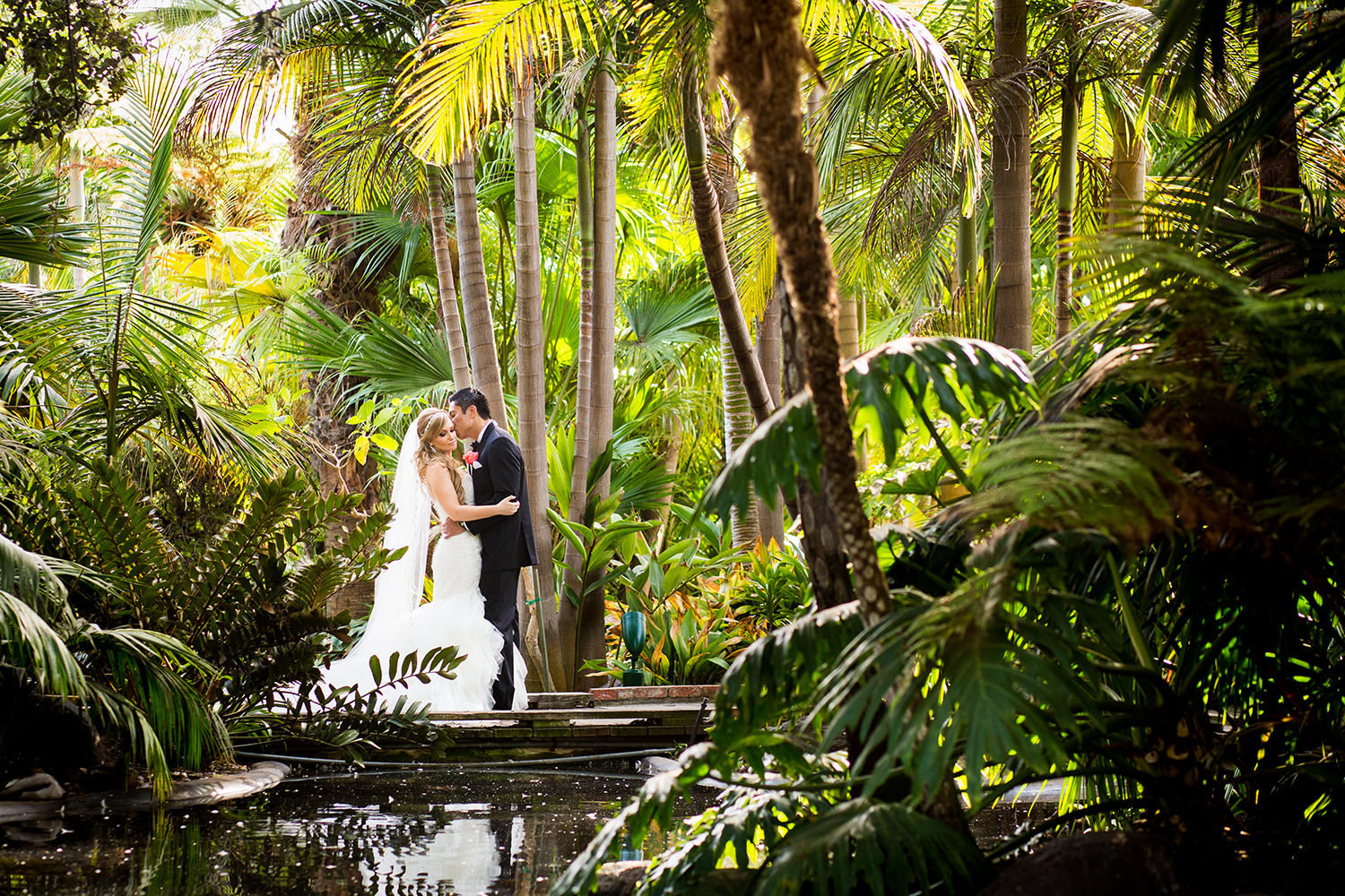 bride and groom on bridge with tropical flowers