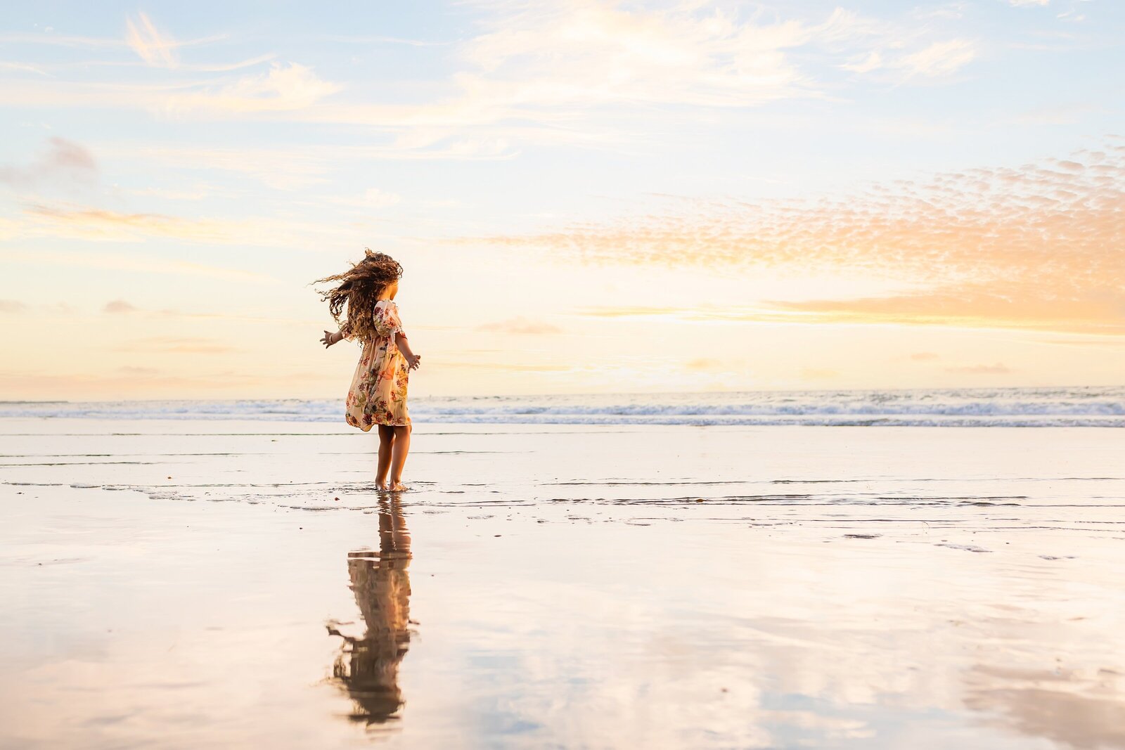 little girl playing near the ocean