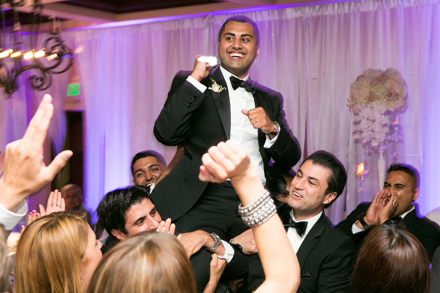 Groom hoisted up in the air during the reception