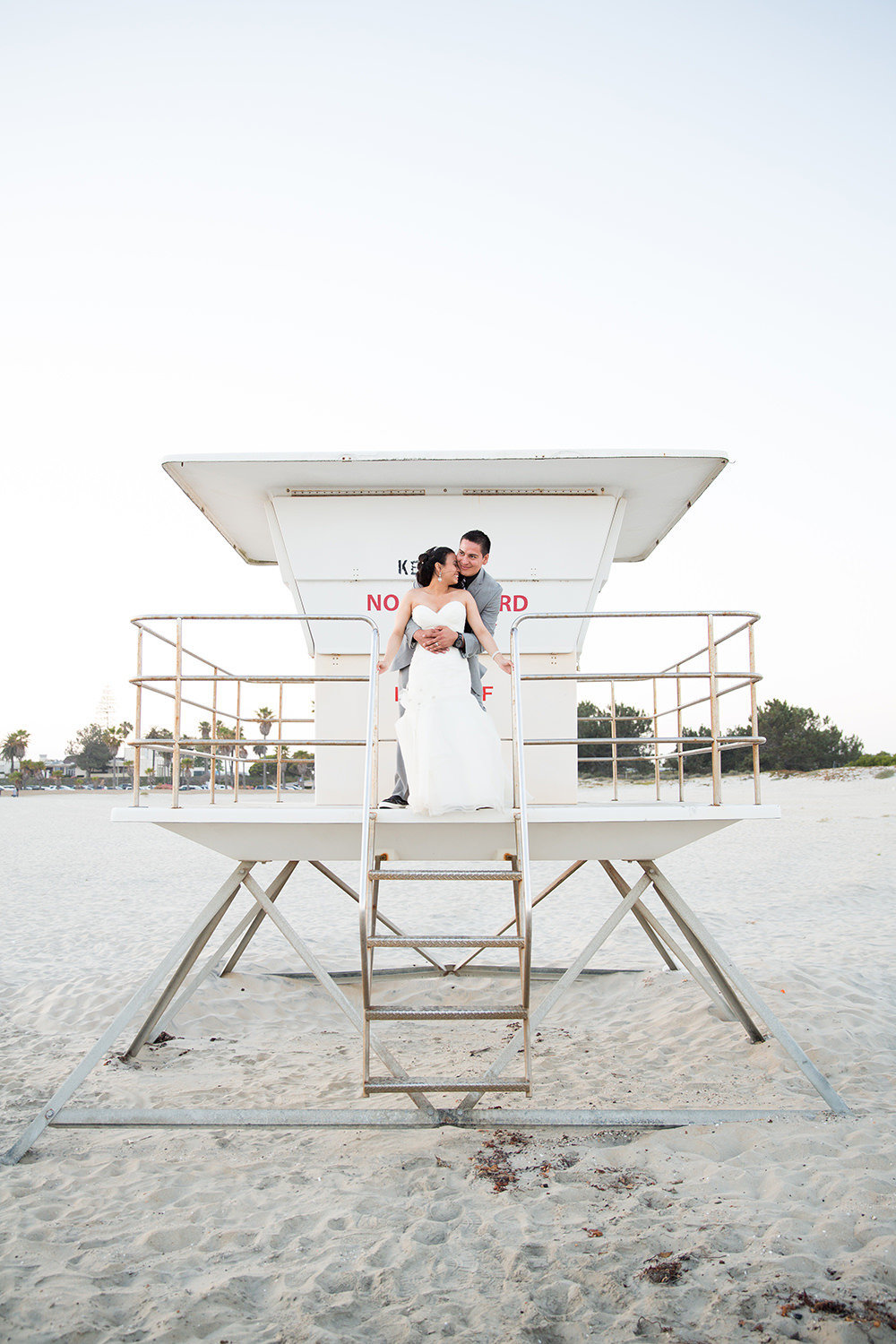 bride and groom on life guard tower at ocean view room