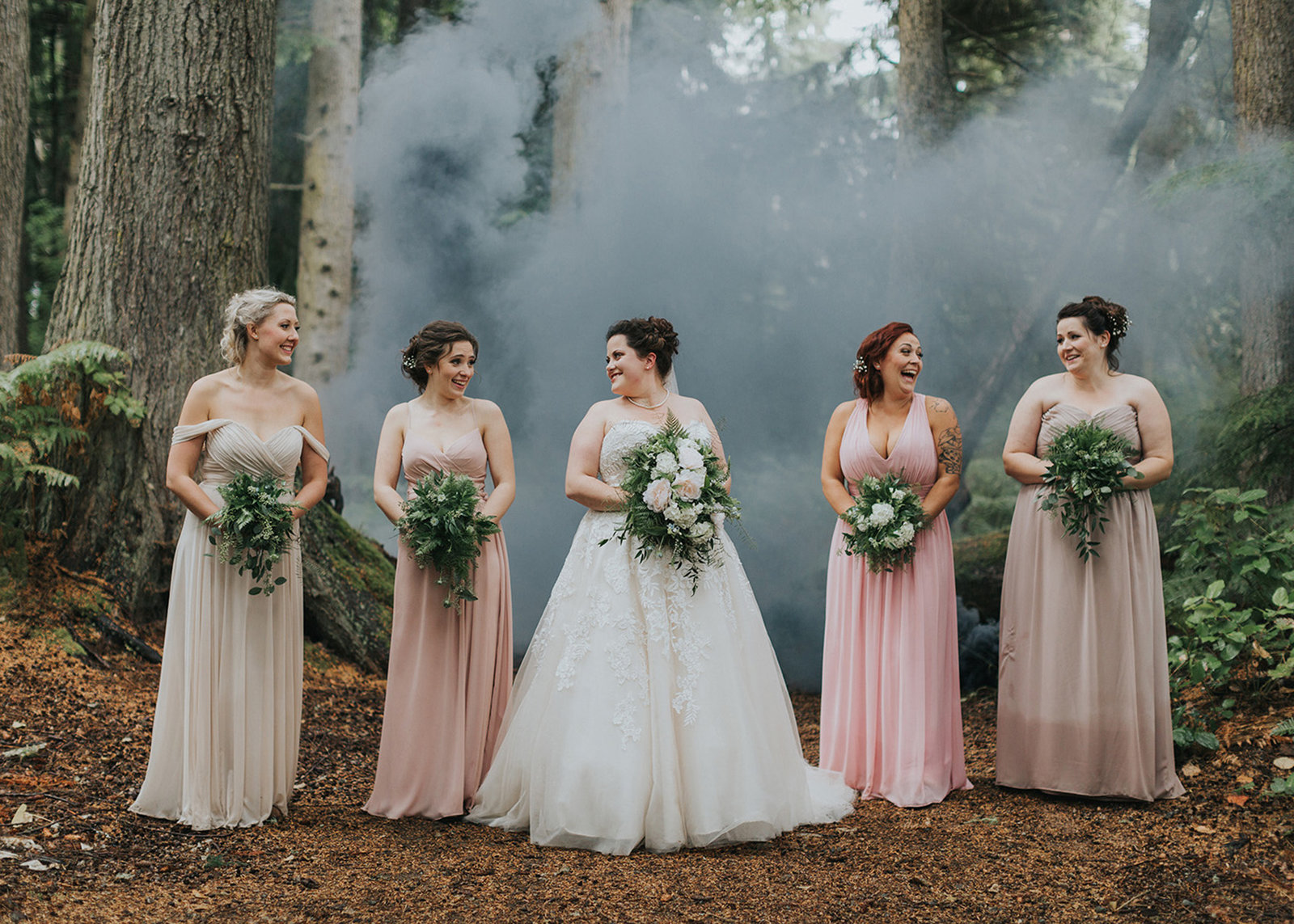 Bride and her bridesmaids sharing a laugh in the forest
