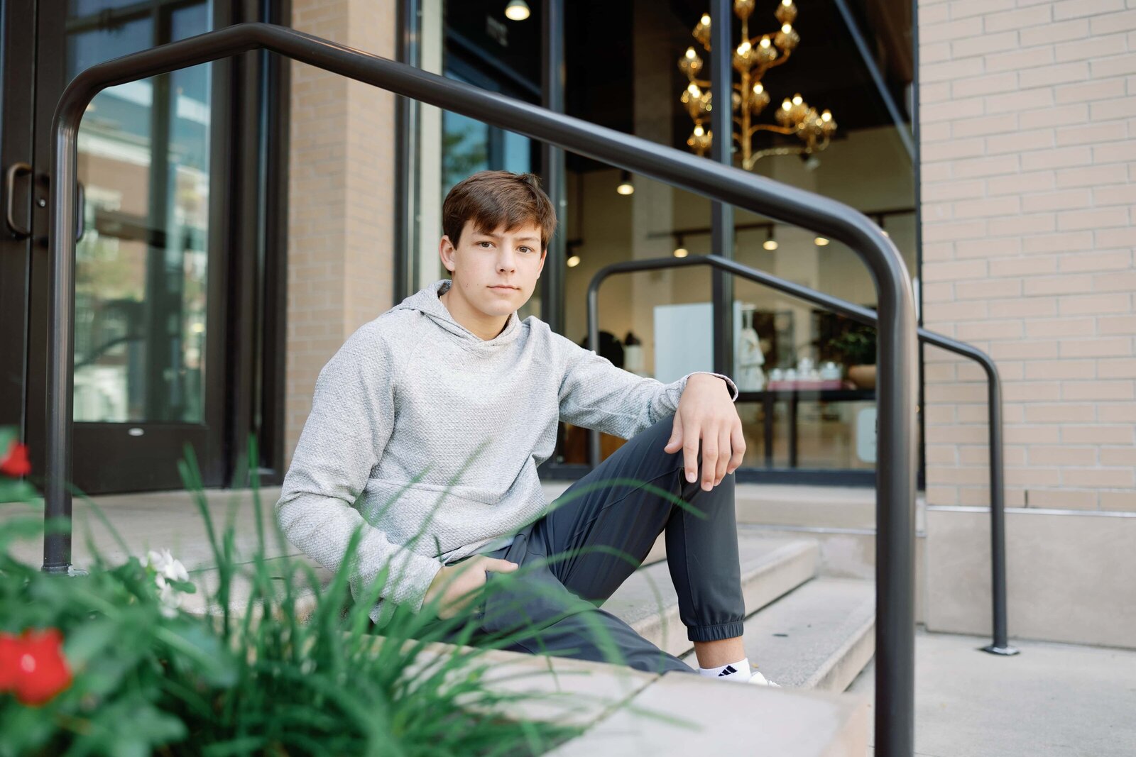 Photo taken by Indianapolis portrait photographer Monette Wagner Photography of high school senior boy sitting on stairs in Carmel IN