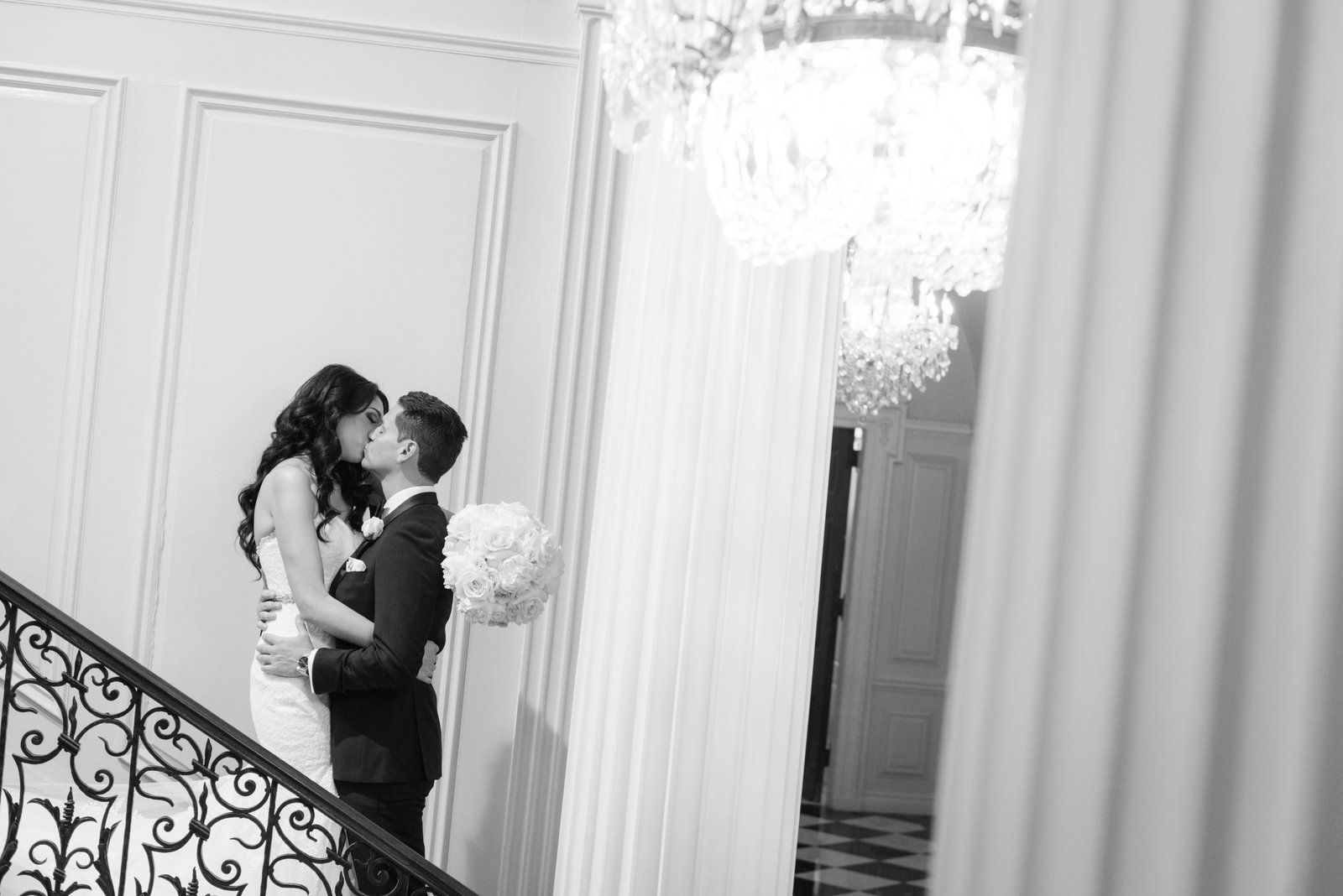 Bride and groom kissing at the stairs at Glen Cove Mansion