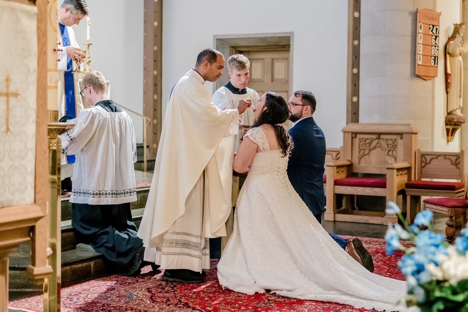 A bride receiving communion during her wedding at St. Rita Catholic Church in Alexandria Virginia