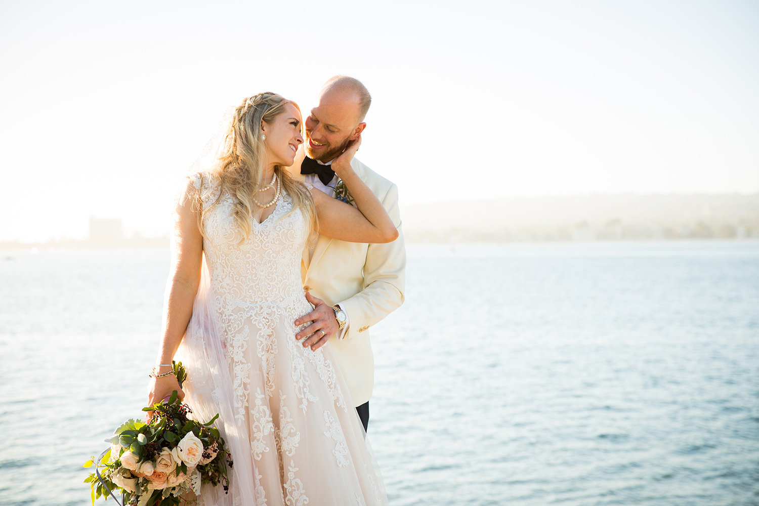 romantic bride and groom with ocean in back ground