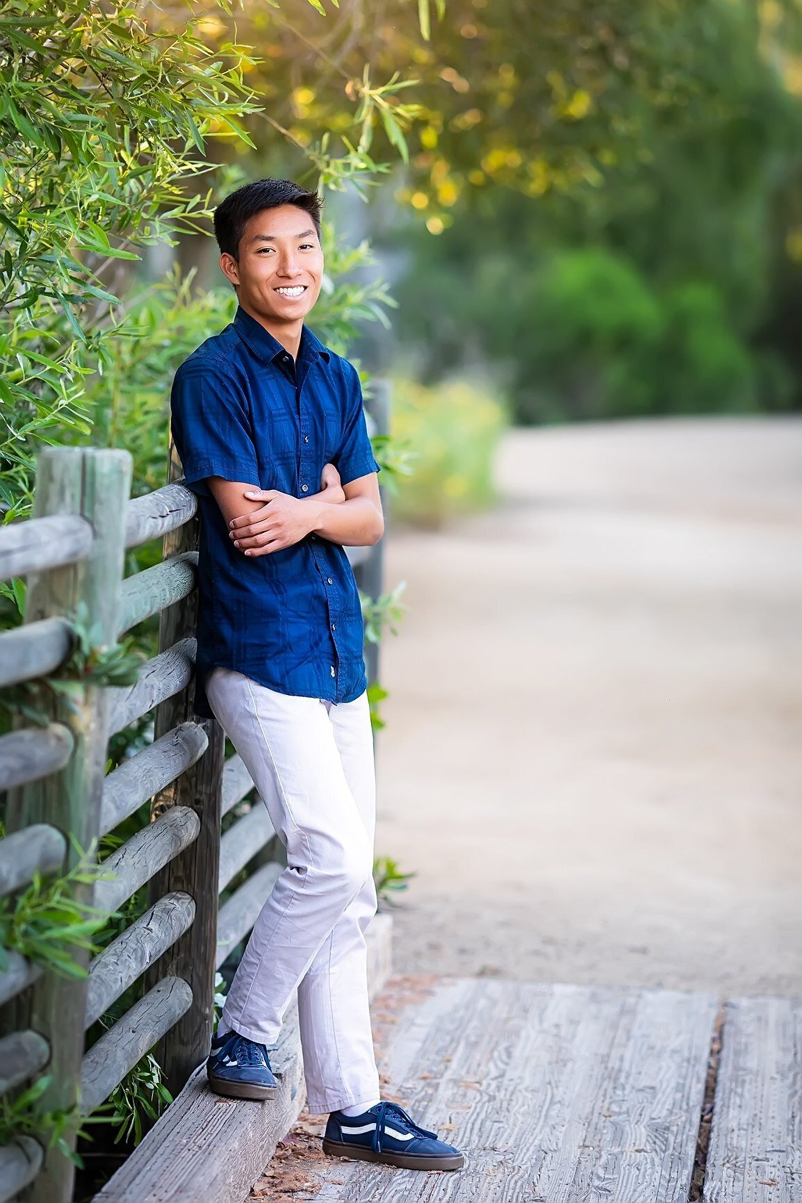 High school senior boy posing by a bridge in San Marcos, CA