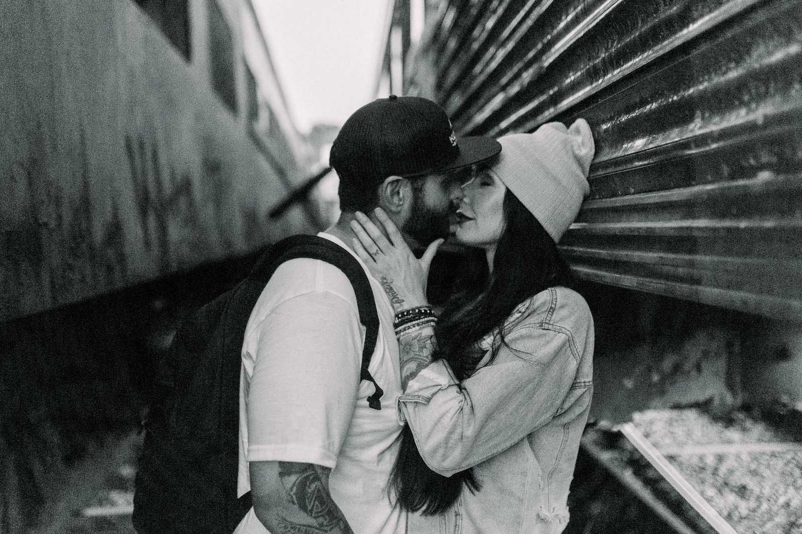 Couple kissing in between train cars captured by Staci Addison Photography