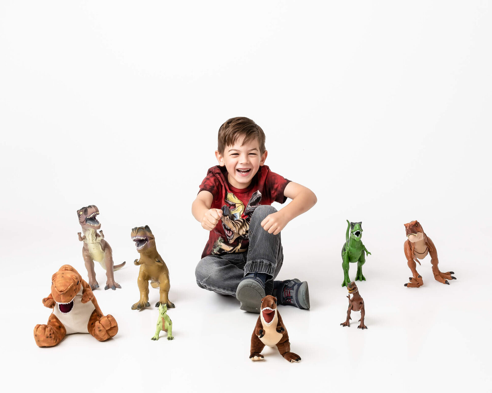 high-key picture of young boy and his dinosaur collection