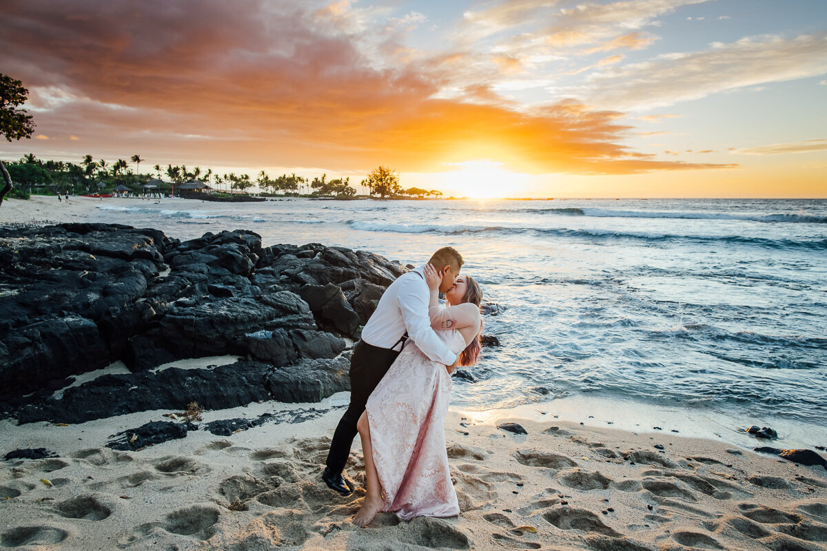 big island sunset as bride and groom kiss
